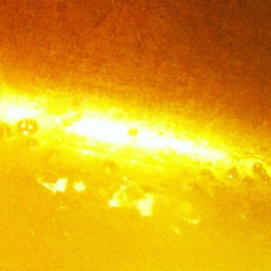Close-up image showing a bright yellow and orange glowing light with a textured surface, resembling intense heat or energy.